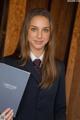 A woman in a suit holding a book.